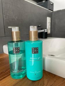 2 bottiglie di sapone sul bancone del bagno di Feriendomizil Möhne mit Seeblick und Sauna a Möhnesee