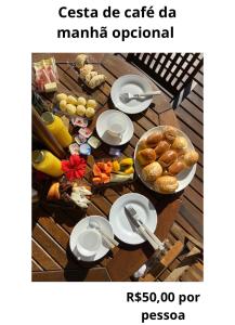 a table topped with plates of food on top at Hospedaria Sol da Manhã in Bombinhas