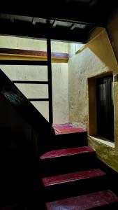 a stair case in a building with red steps at Heritage Homestay in Chikmagalūr