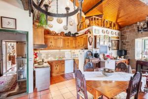 a kitchen with wooden cabinets and a table with chairs at Solar dos Carvalhos in Sernancelhe