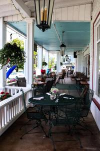 eine Terrasse mit einem Tisch und Stühlen auf einer Veranda in der Unterkunft Fullerton Inn & Restaurant in Chester