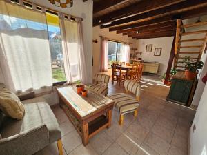 a living room with a couch and a table and chairs at Yellow House Cottage in El Chalten