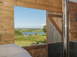 a bedroom with a window with a view of a lake at The Snug in Dulverton