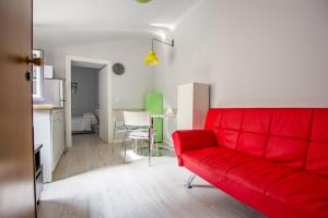 un soggiorno con un divano rosso e una cucina di Viale 24 a Trieste