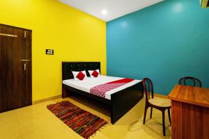 1 dormitorio con 1 cama con paredes amarillas y azules en OYO Flagship Raj Munmun Hotel, en Dhanbād
