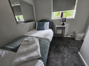 ein kleines Schlafzimmer mit einem Bett und einem Spiegel in der Unterkunft Jersey Cottage in Horseheath