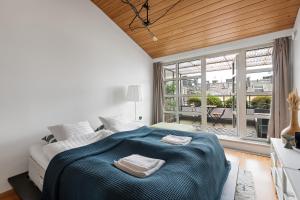 ヘルシンキにあるWeHost Penthouse Studio with Sauna and Balcony @Meritullinkatu 13 Aのベッドルーム1室(ベッド1台、タオル2枚付)