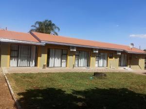 un edificio amarillo con techo rojo en Lasev Resort, en Pretoria