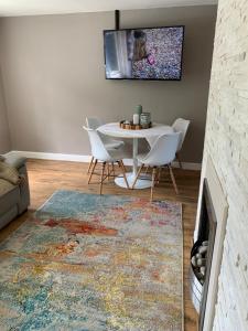 a living room with a table and chairs and a fireplace at Lambley view 