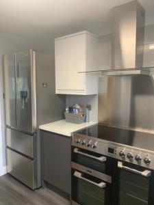 a kitchen with a stove and a stainless steel refrigerator at Lambley view 