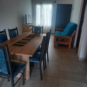 a dining room with a wooden table and chairs at Cabañas Plottier-Neuquén in Plottier