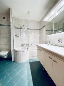 a bathroom with a shower and a sink and a toilet at Haus Alpina - CharmingStay in Flumserberg