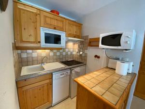 een kleine keuken met een wastafel en een magnetron bij Appartement pied des pistes, 4 personnes, 1 chambre - MONT02 in Beaufort