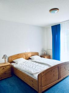 a bedroom with a wooden bed and a window at Haus Alpina - CharmingStay in Flumserberg