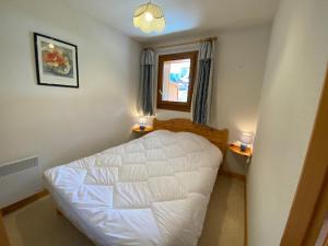 een kleine slaapkamer met een wit bed en een raam bij Appartement pied des pistes, 4 personnes, 1 chambre - MONT02 in Beaufort