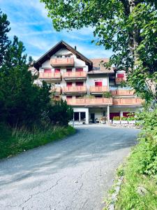 ein Gebäude mit roten Balkonen an der Straßenseite in der Unterkunft Haus Alpina - CharmingStay in Flumserberg