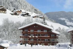 een gebouw bedekt met sneeuw met een berg bij Appartement pied des pistes, 4 personnes, 1 chambre - MONT02 in Beaufort