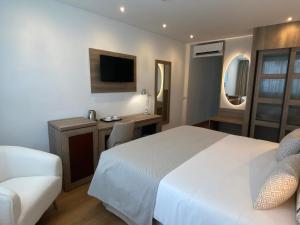 a bedroom with a bed and a desk and a tv at Hotel Colon Rambla in Santa Cruz de Tenerife