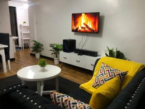 Una sala de estar con un sofá y un televisor en la pared. en Comfort Stay, en Nakuru