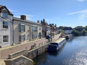 a boat is docked in a canal next to buildings at Two Bedroom Duplex Apartment The Priory - St Ives in St Ives