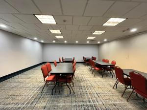 una sala de conferencias con mesas y sillas. en Country Inn & Suites by Radisson, Harrisburg - Hershey West, PA, en Harrisburg