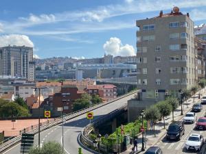 una calle de la ciudad con coches aparcados en una autopista en Apartamento HALO VIGO, en Vigo