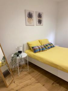 Un dormitorio con una cama amarilla y una mesa en Apartamento HALO VIGO, en Vigo