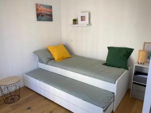Dormitorio pequeño con cama con almohada amarilla y verde en Apartamento HALO VIGO, en Vigo