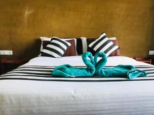 a bed with two turquoise towels on it at Monarch Ella in Ella
