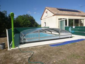 una piscina con una valla verde y una piscina en Gîte à la "traverse" des chemins en Lalbenque