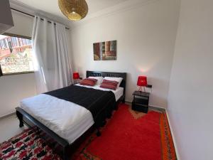 La Maison de Mohamed في Wassane: غرفة نوم بسرير وسجادة حمراء