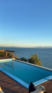 a swimming pool with a view of the water at Sitio do Ma Vio in Governador Celso Ramos