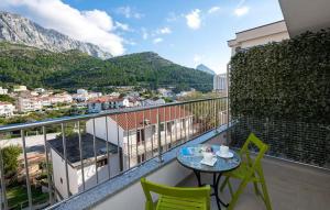 a balcony with a table and chairs and mountains at Apartmani Valentina Drvenik in Drvenik