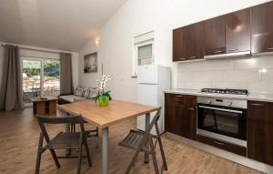 a kitchen with a table and chairs and a stove and refrigerator at Apartmani Valentina Drvenik in Drvenik