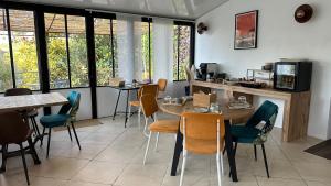 uma sala de jantar com mesas, cadeiras e janelas em Chambre Ginkgo au Domaine de l'Aven em Villeneuve-Minervois