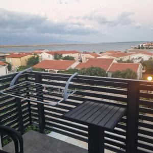 un banco en un balcón con vistas al agua en Apartments Nada, en Vir