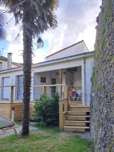 a house with a palm tree in front of it at L'Hématite in Les Épesses