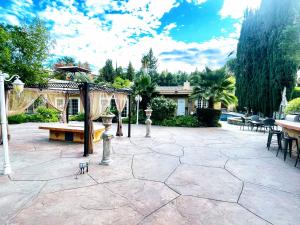 un patio con banco y cenador en Vacation Paradise - 6 BR Mansion on Top of Encino Hills en Topanga