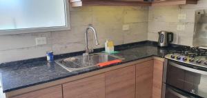 a kitchen counter with a sink and a stove at Rock Apart in Puerto Madryn