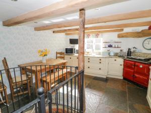 a kitchen with white cabinets and a wooden table at Millstone House in Lutterworth
