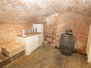 a wine cellar with a barrel and a table with wine bottles at Millstone House in Lutterworth +35 photos