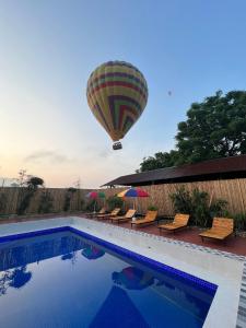 a hot air balloon flying over a swimming pool at Vang Vieng Chill House in Vang Vieng
