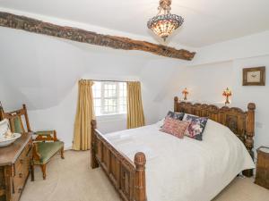 a bedroom with a wooden bed and a window at Millstone House in Lutterworth