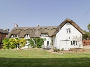 a large white house with a thatched roof at Millstone House in Lutterworth