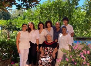 a family posing for a picture in a garden at Hotel Villa Degli Aranci in Maratea