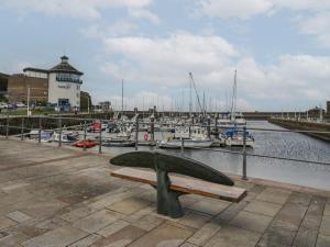 a bench at a marina with boats in the water at 8 Corkickle in Whitehaven