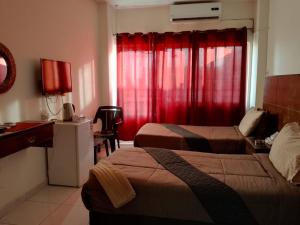 a hotel room with two beds and a red curtain at Amir Palace Hotel in Aqaba