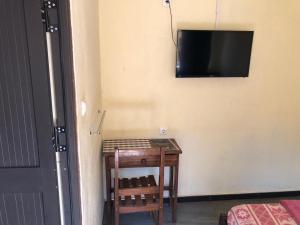 a room with a table and a television on the wall at Residencial Meu Tio in Chimoio