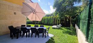 a table with chairs and an umbrella in a yard at Viento Del Norte in Pomar