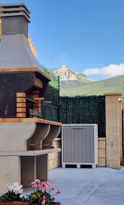 a building with a grill and flowers in a yard at Viento Del Norte in Pomar